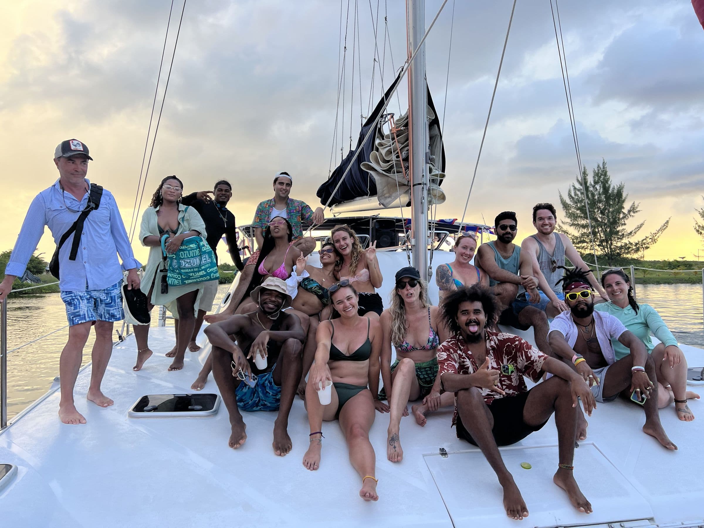 Large group relaxing on a sailboat at golden hour