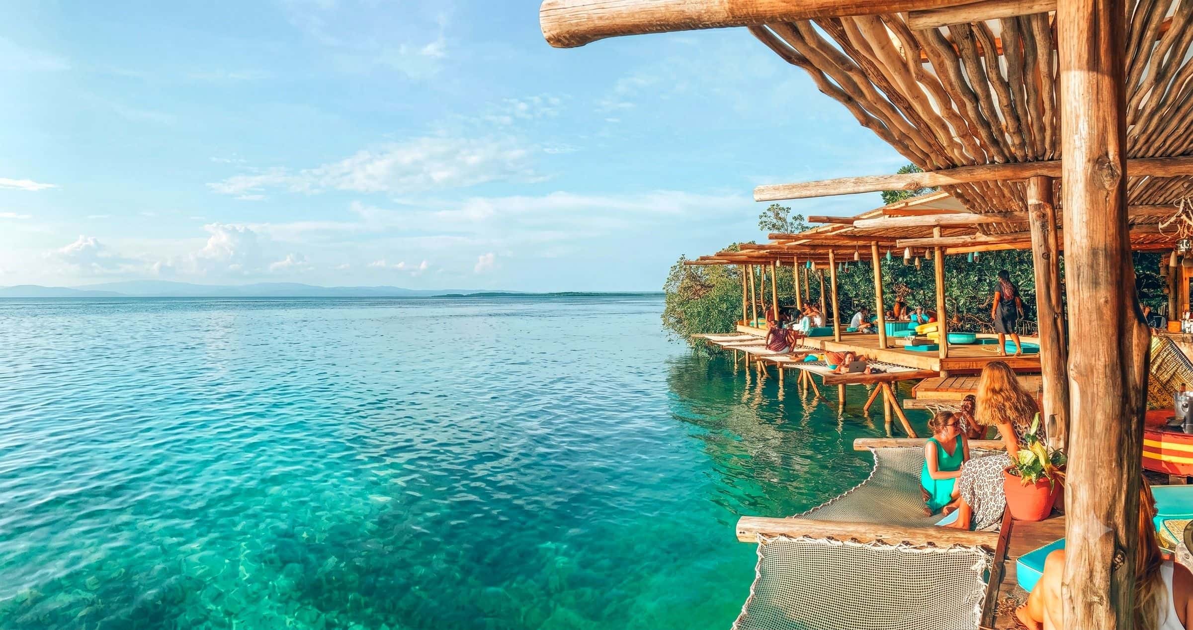 Noma Collective overwater bamboo lounge over turquoise water